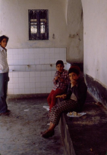 Trois garçons dans la salle des ablutions de la synagogue de la Ghriba